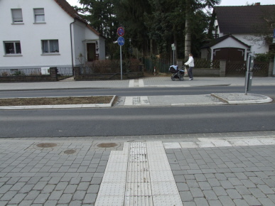 Querungsstelle mit differenzierter Bordhöhe, Sperrfeld warnt Blinde vor Bordabsenkung mit Rollbord, Richtungsfeld im Auffindestreifen integiert