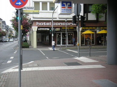 Bordabsenkung mit Rollbord. Die wichtigste Querungshilfe ist für Sehbehinderte die Lichtsignalanlage mit Vibrator am Taster und Akustik. Ein Auffindestreifen führt zum Ampelmast.