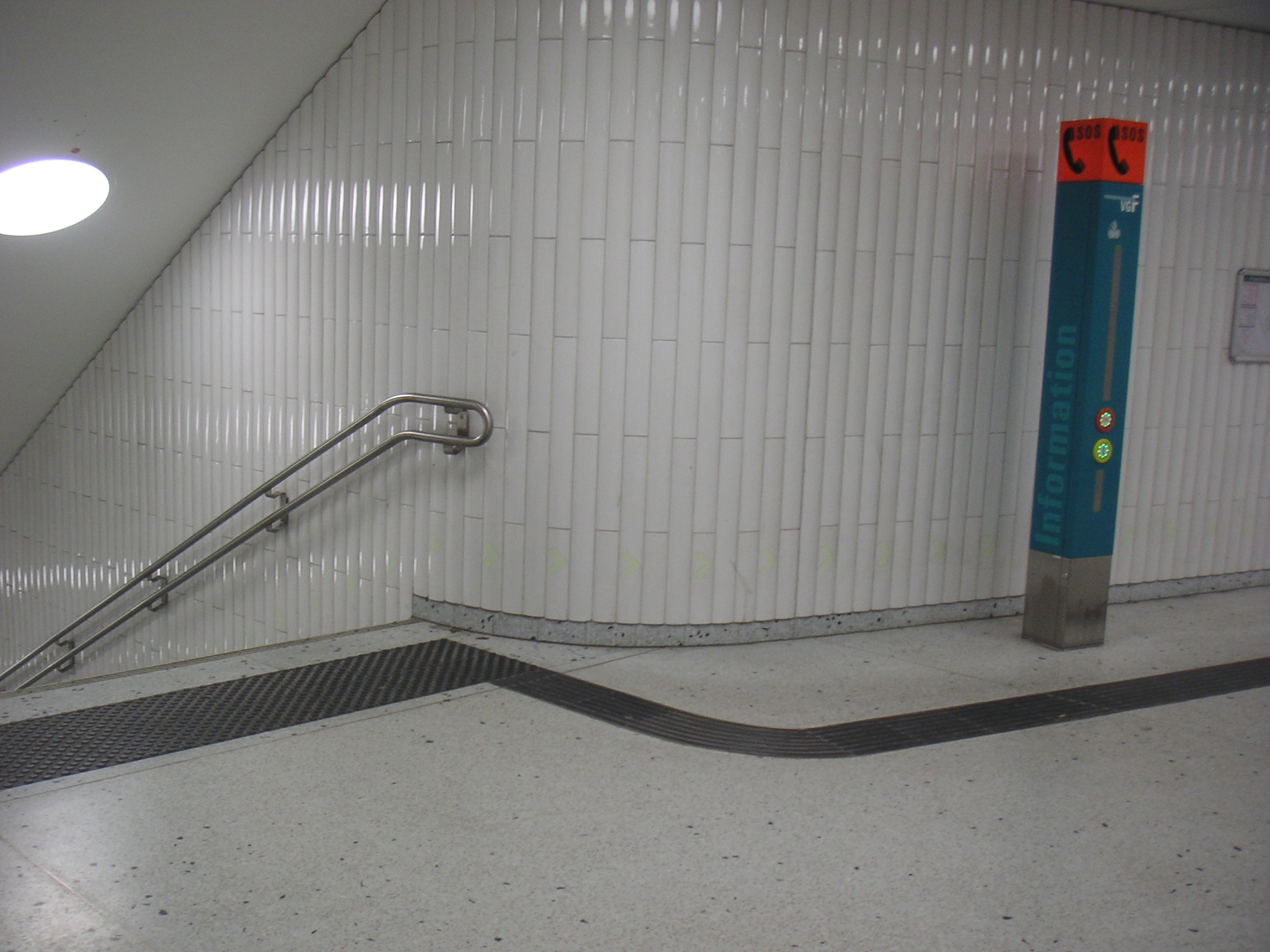 Treppenanlage U-Bahn Frankfurt. Das Noppenfeld warnt vor der Treppe, der Leitstreifen führt zum Handlauf, der an den Enden 30 cm waagerecht läuft.